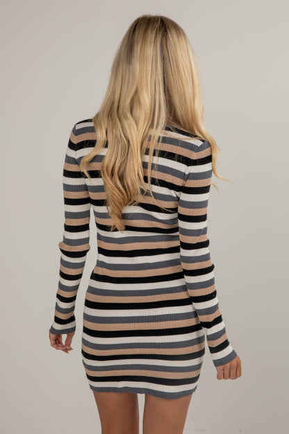 Woman wearing a striped long-sleeve dress against a plain background