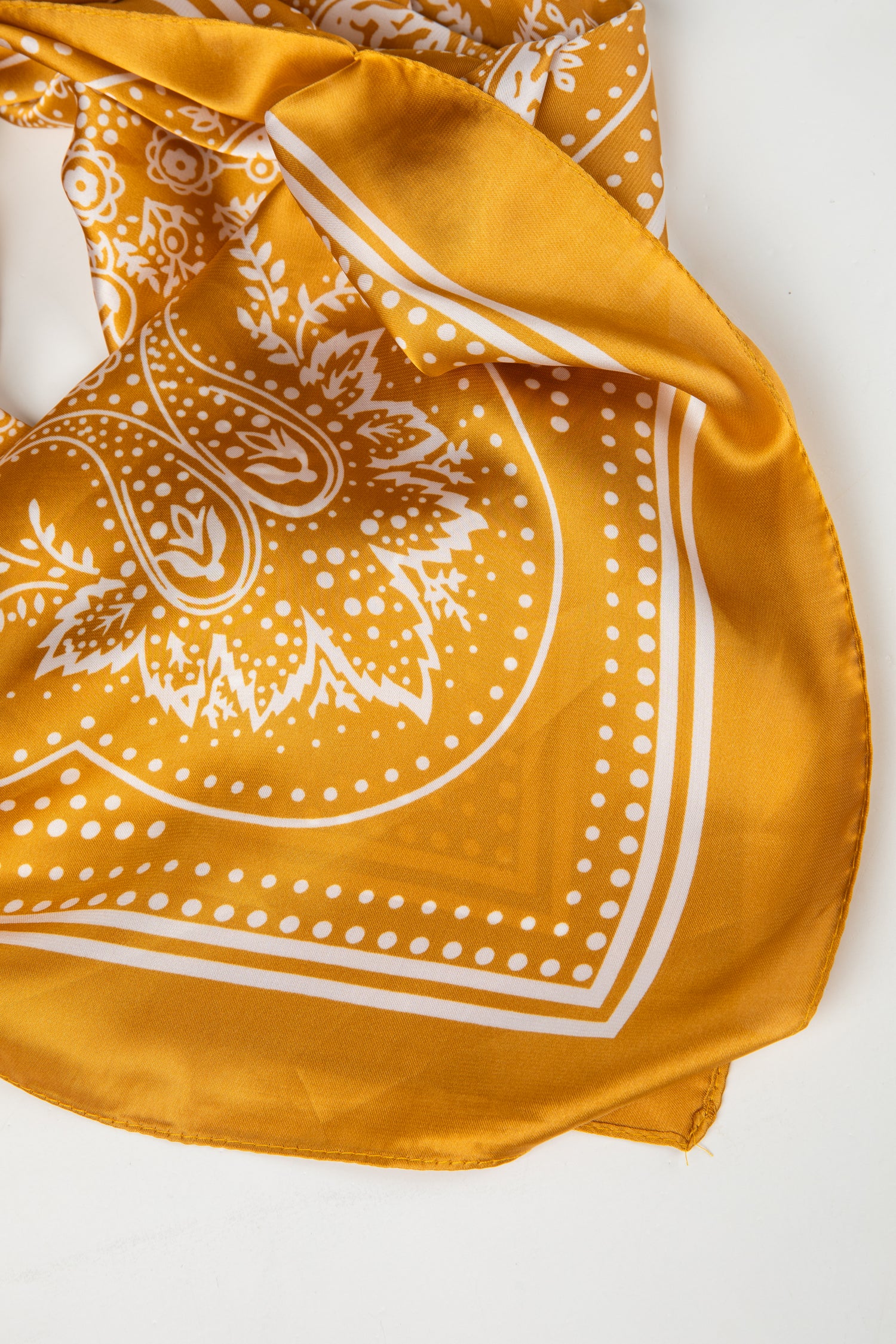 Yellow bandana with white patterns on a white background