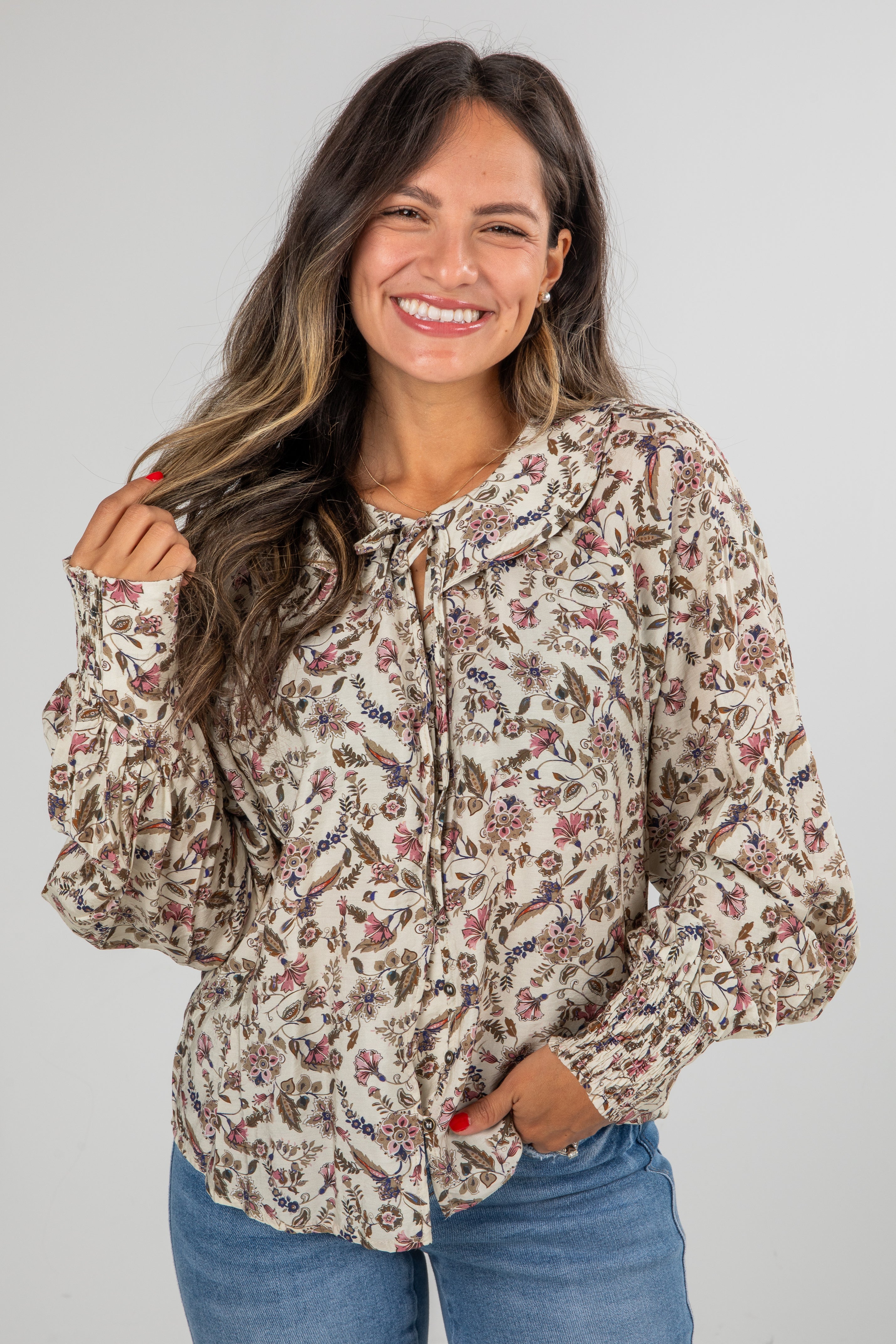 Woman wearing a floral blouse with a plain background