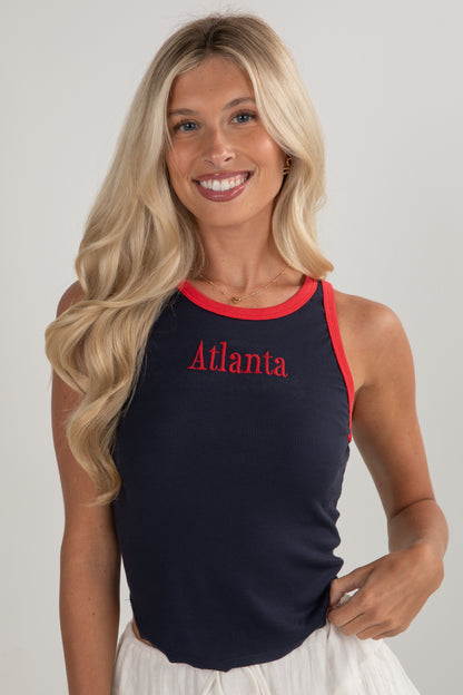 Woman wearing a navy tank top with red trim and &