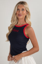 Woman wearing a black tank top with red trim and &
