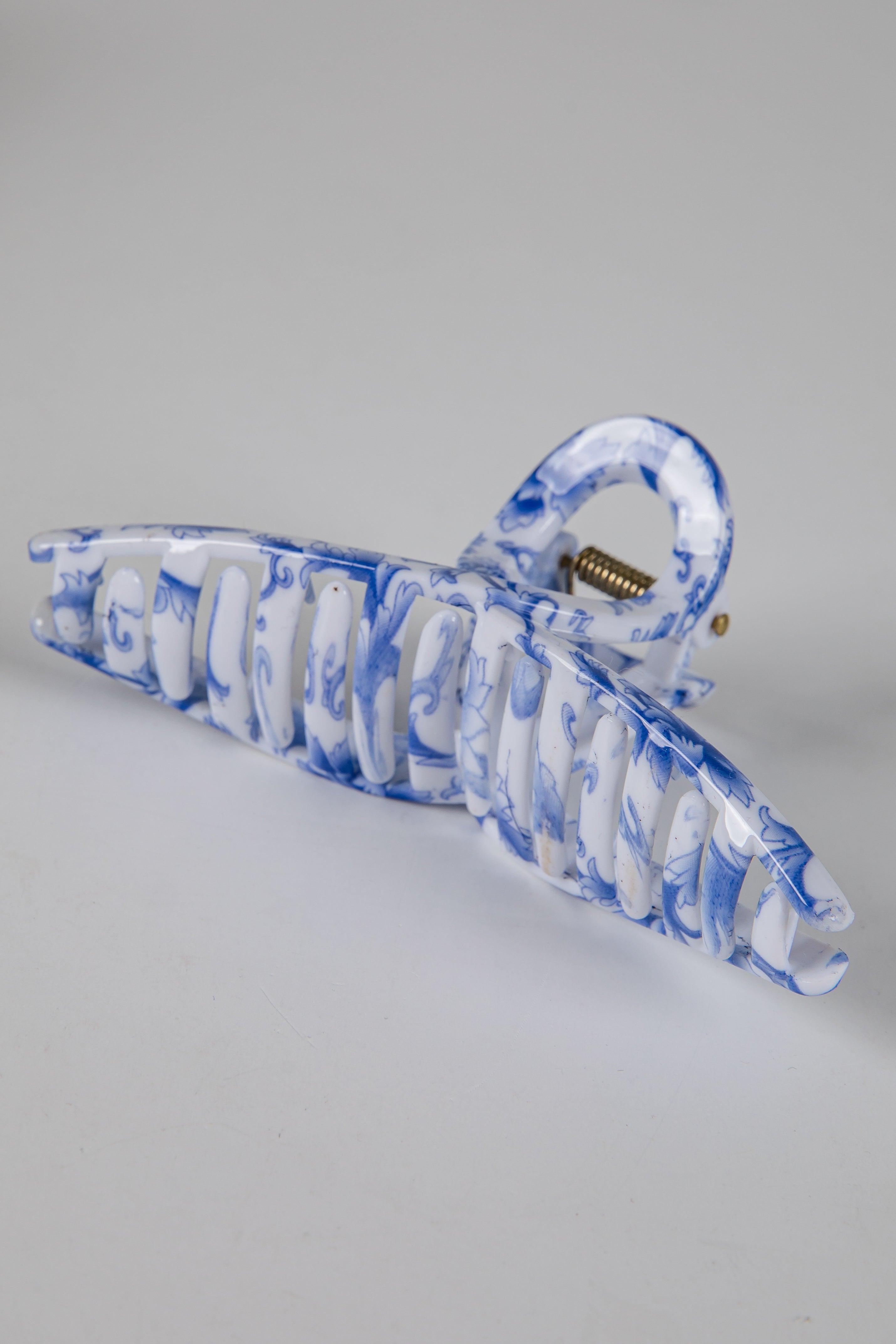 Blue and white marbled hair clip on a gray background