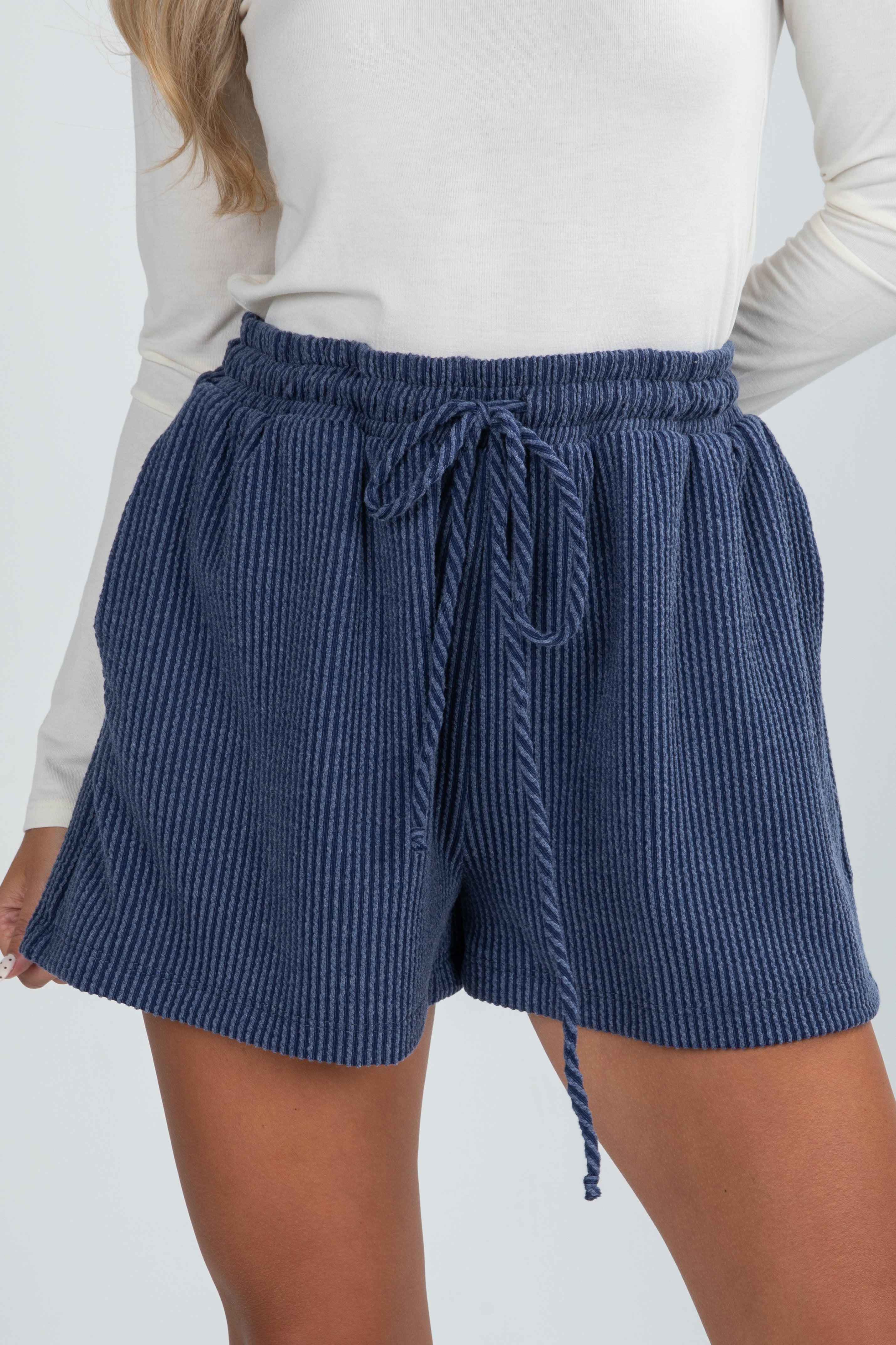 Blue ribbed shorts with a drawstring on a white background