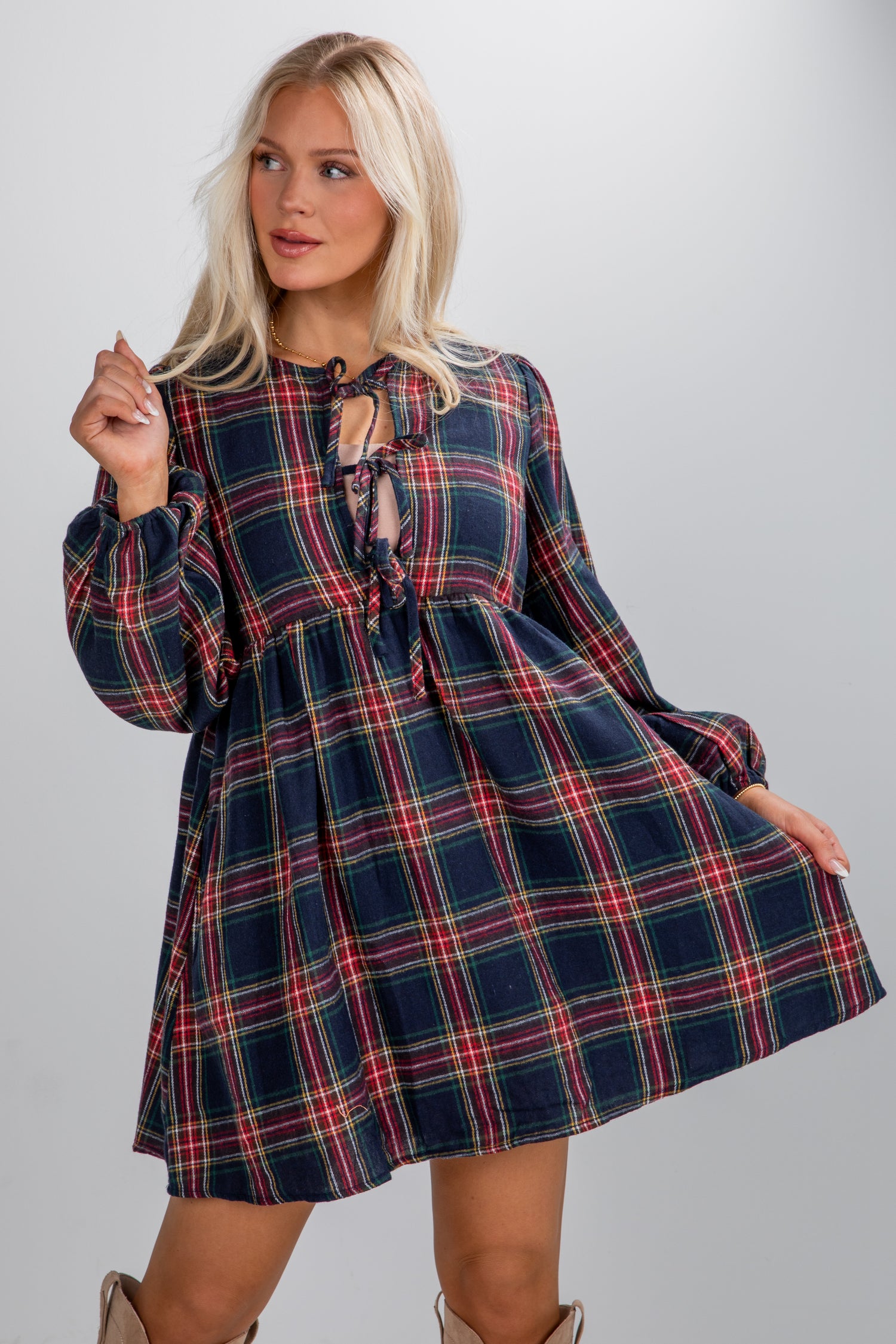 Woman wearing a plaid dress against a plain background