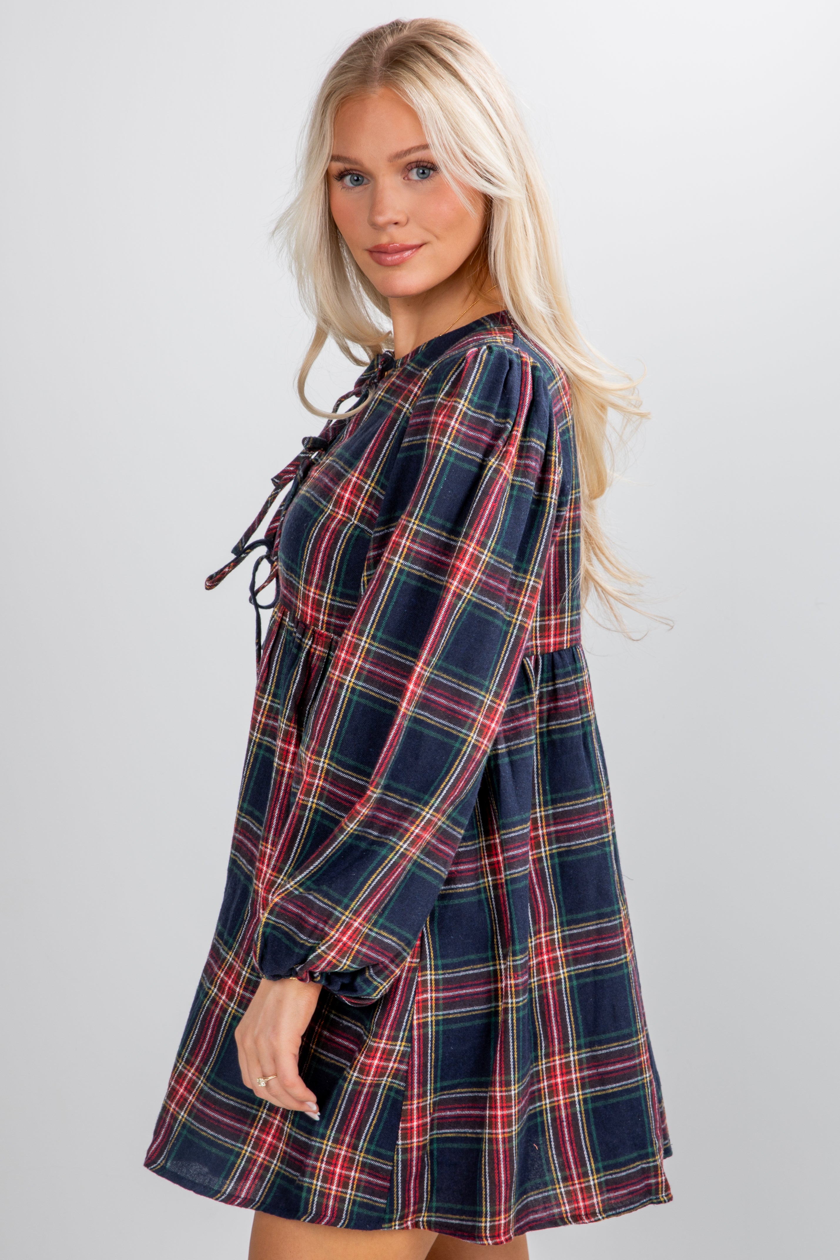 Woman wearing a plaid dress on a plain background