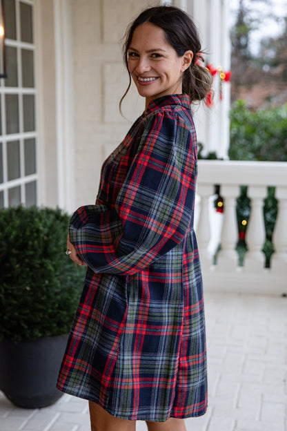 Woman wearing a plaid dress on a porch