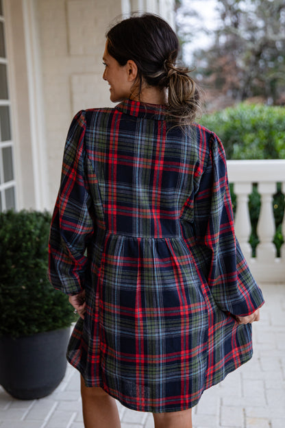 Woman wearing a plaid dress on a porch