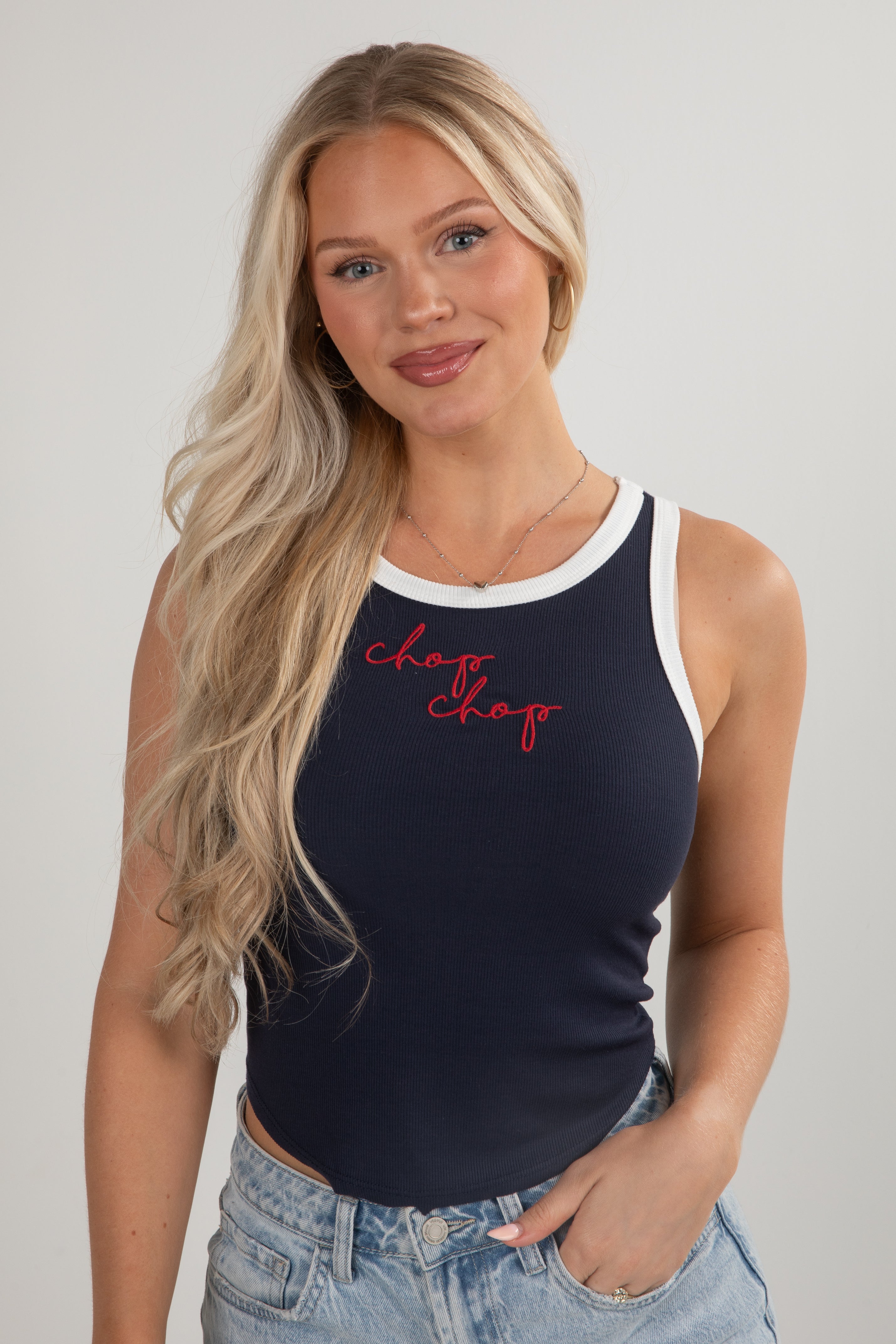 Woman wearing a navy tank top with red text on a plain background