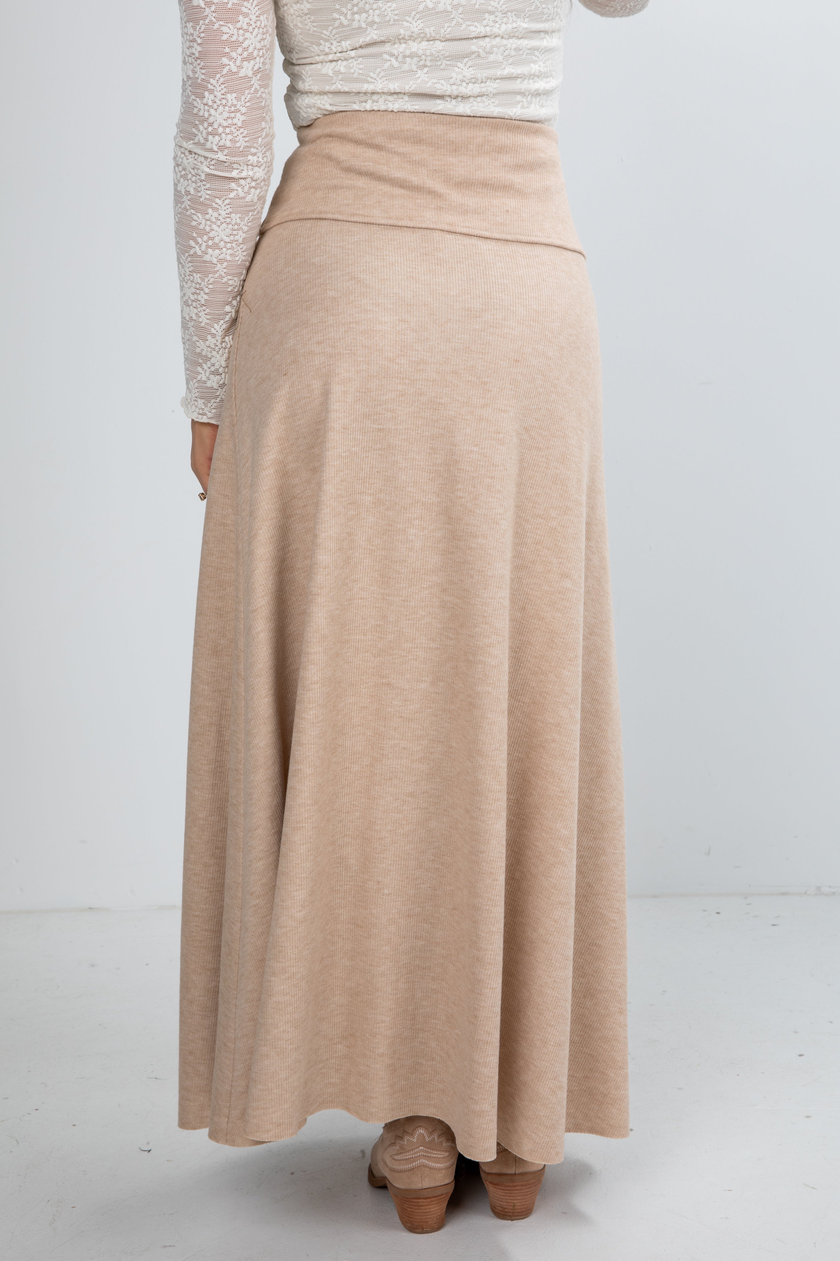 Person wearing a beige skirt on a white background