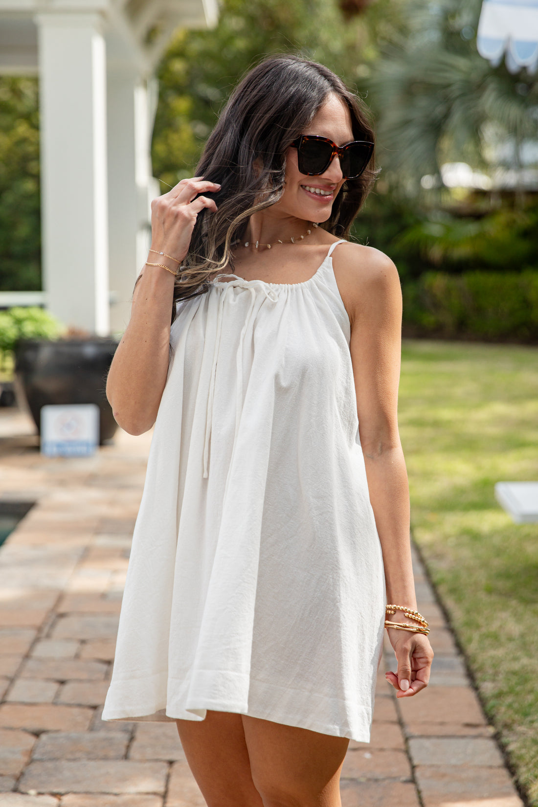 Woman wearing a white dress outdoors on a sunny day