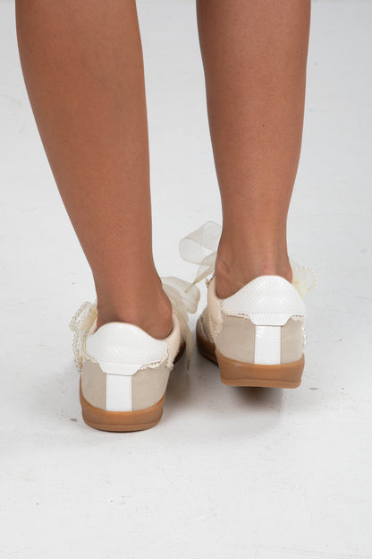 White and brown shoes worn by a person on a white background