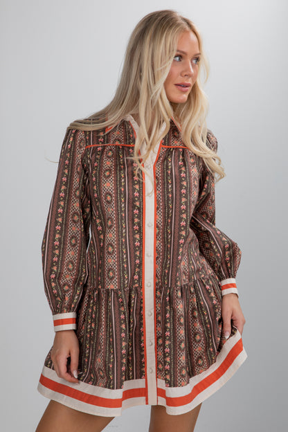 Woman wearing a patterned dress with a plain background