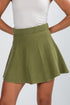 Green skirt worn by a person on a plain background