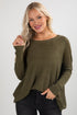 Woman wearing an olive green sweater against a white background