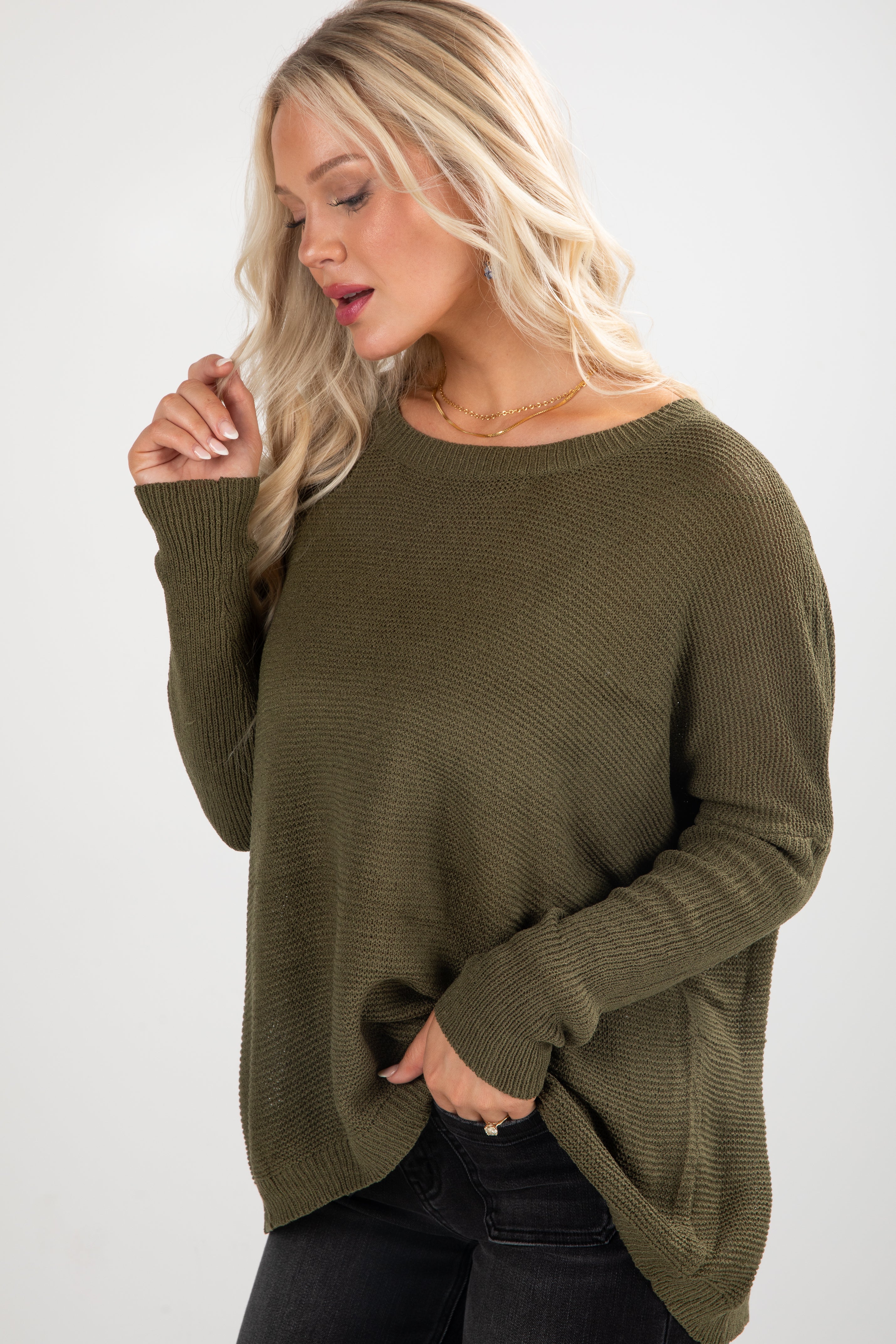 Woman wearing an olive green sweater against a white background