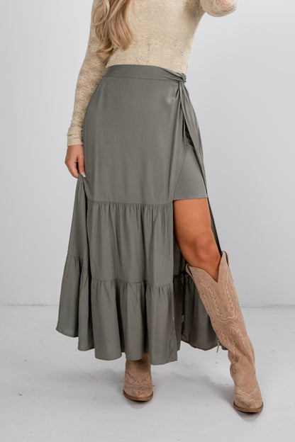 Person wearing a long green skirt with a white background
