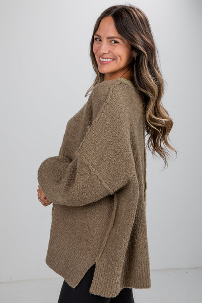 Woman wearing a brown sweater against a white background