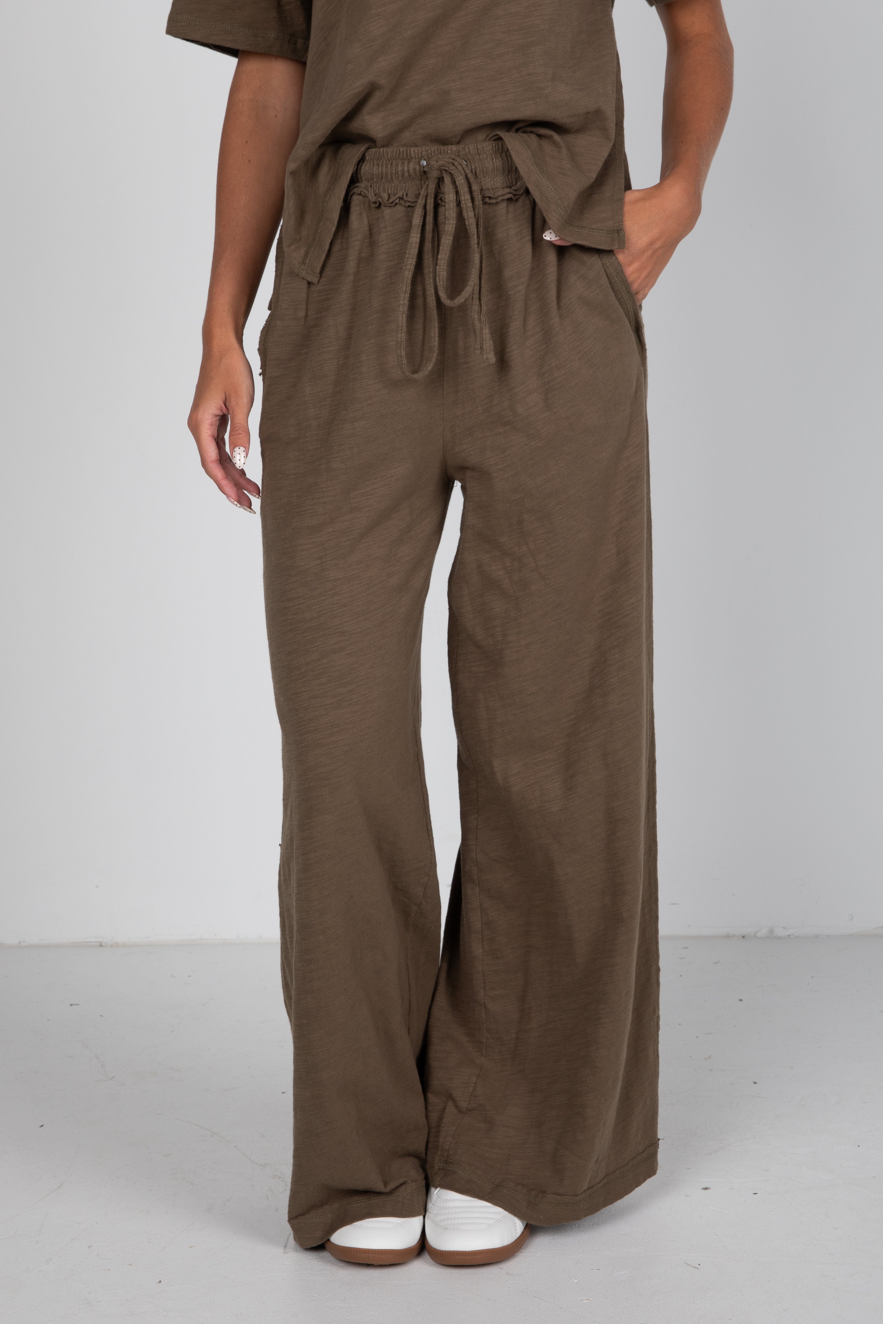 Brown wide-leg pants worn by a person on a white background