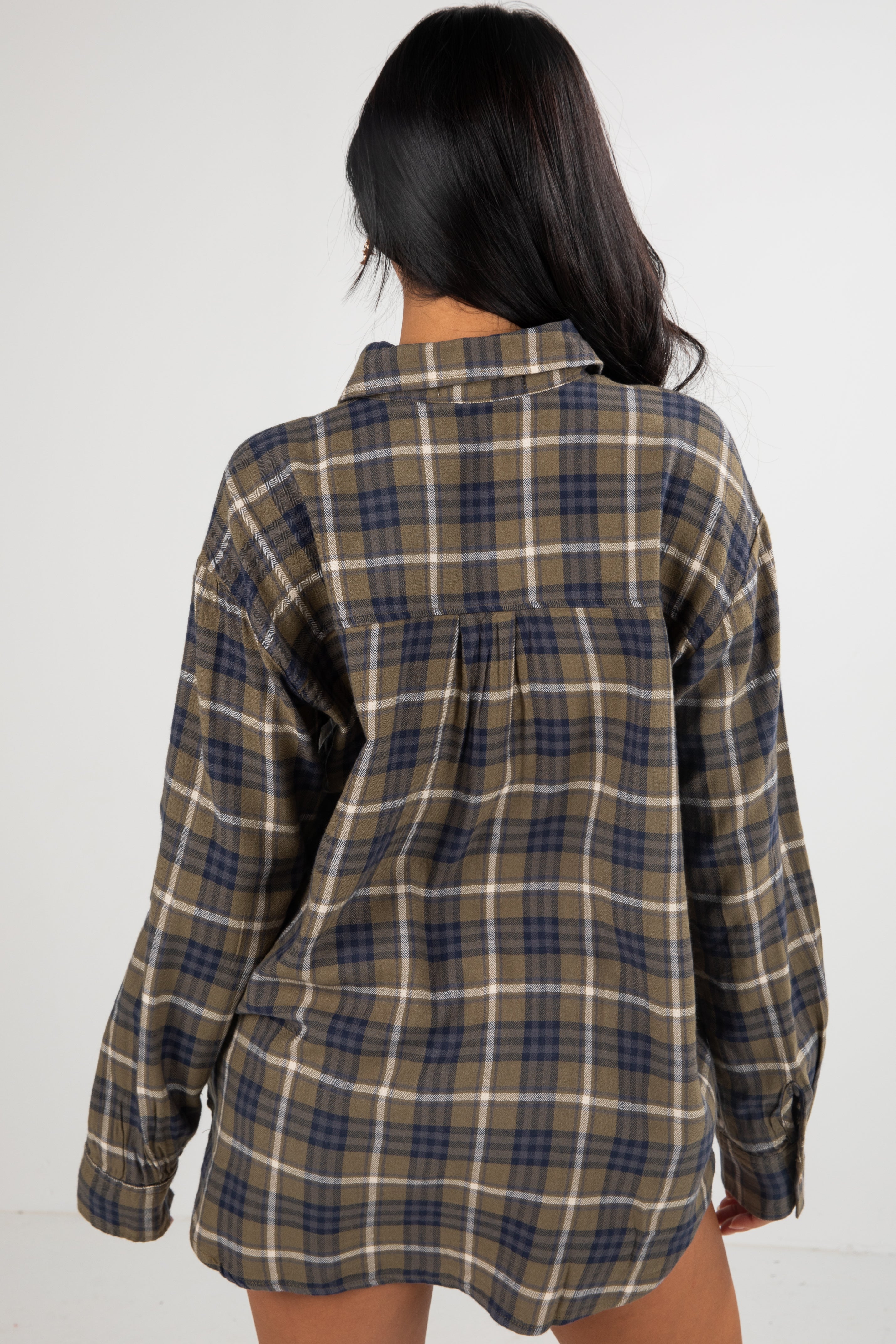 Person wearing a plaid shirt with a white background