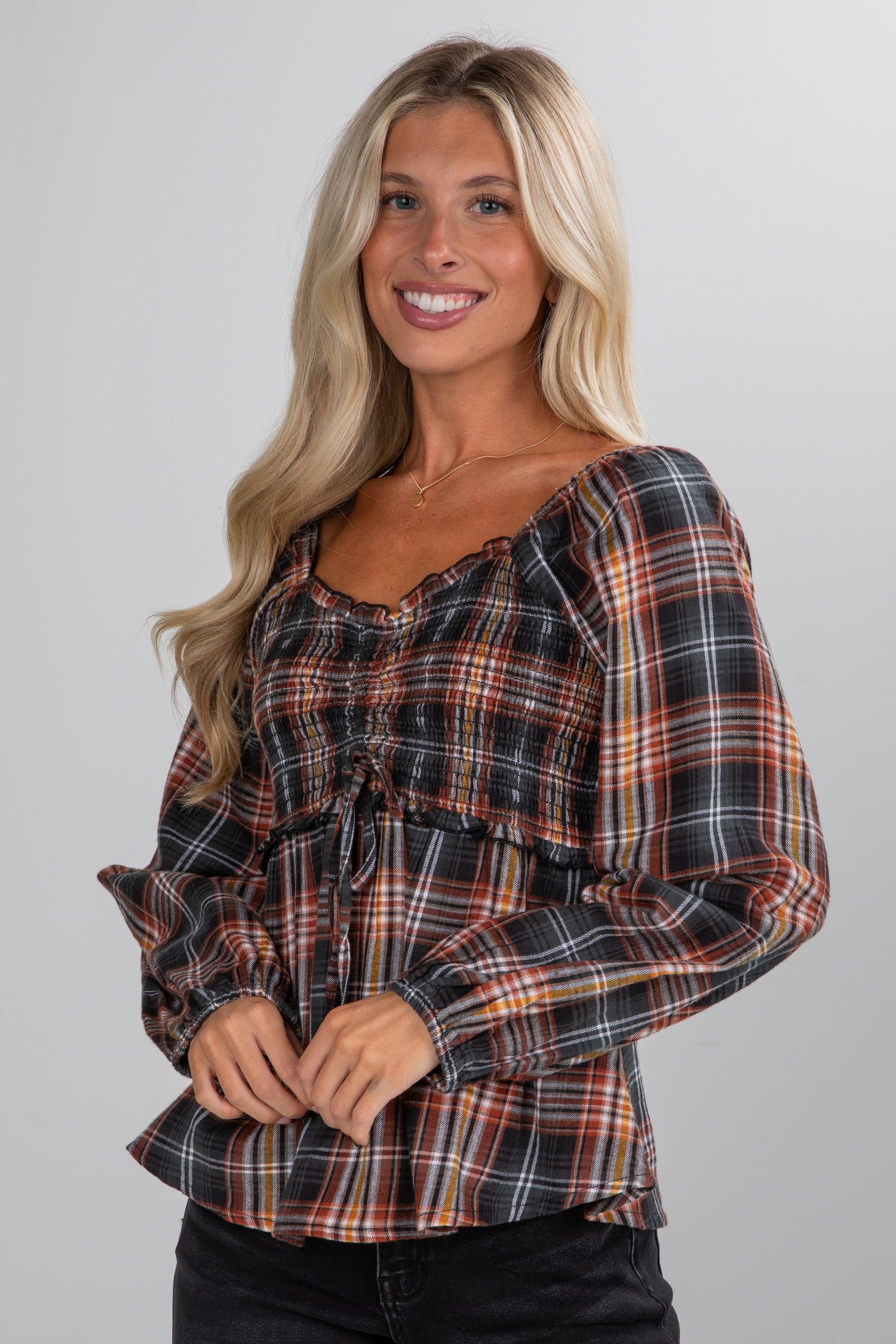 Woman wearing a plaid shirt against a plain background