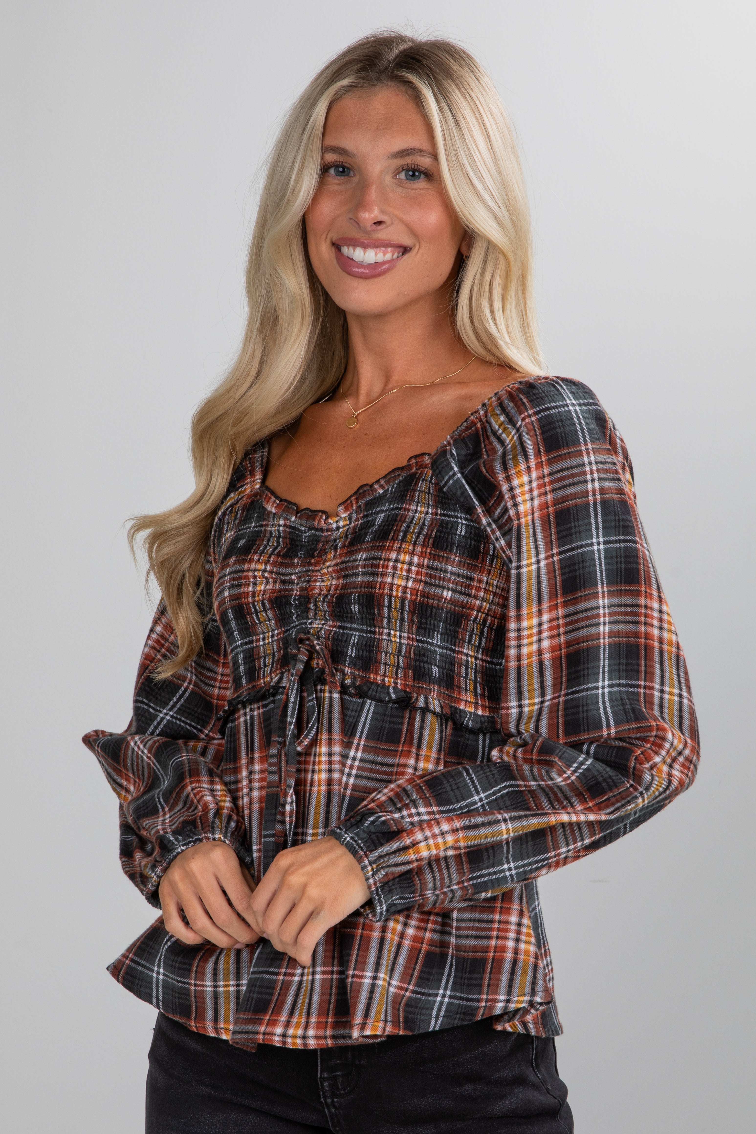 Woman wearing a plaid shirt against a plain background