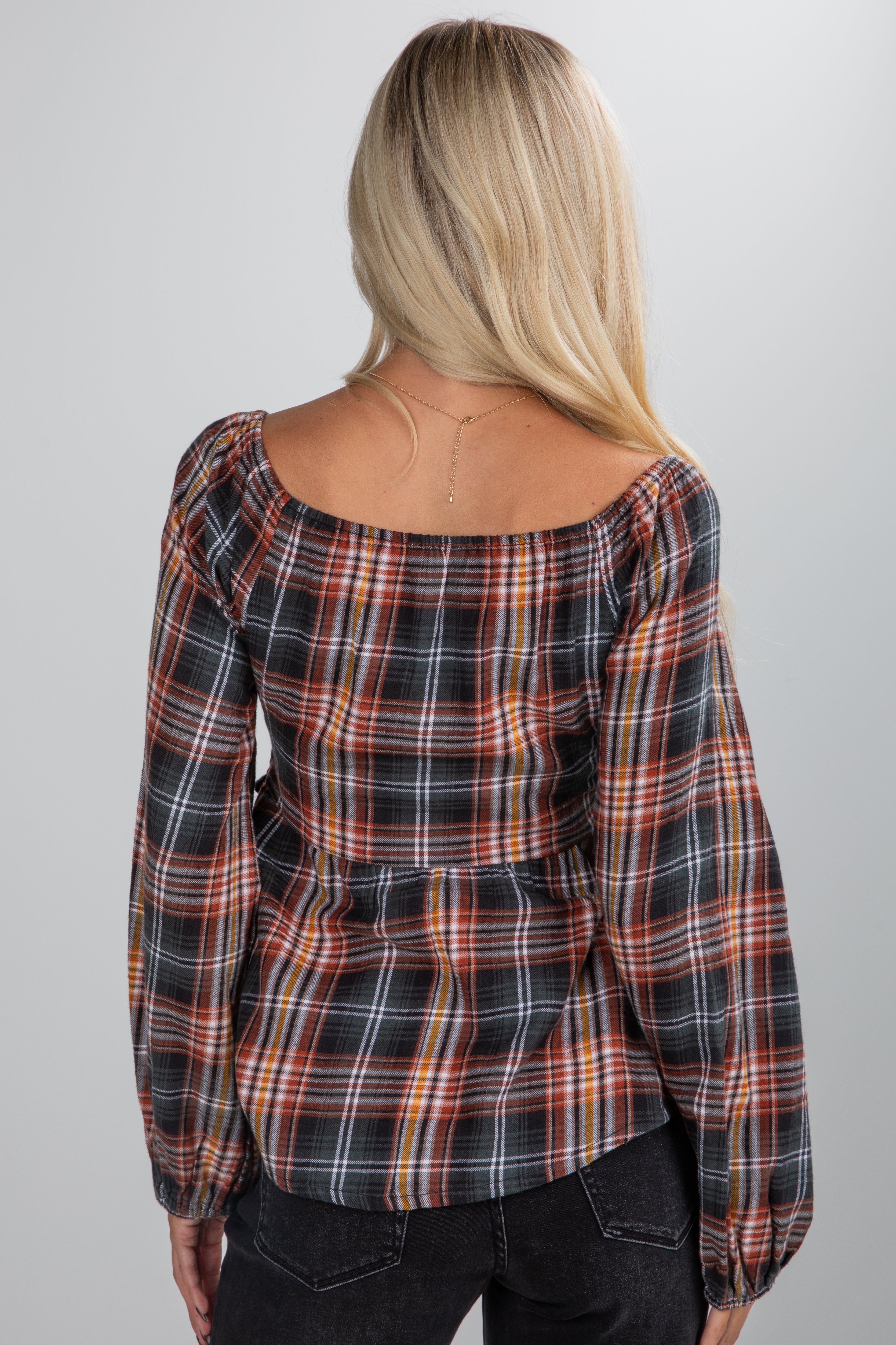 Person wearing a plaid shirt from behind on a plain background