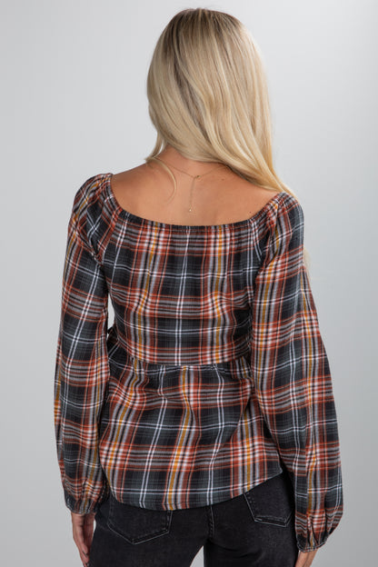 Person wearing a plaid shirt from behind on a plain background