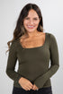Woman wearing an olive green long-sleeve top against a white background