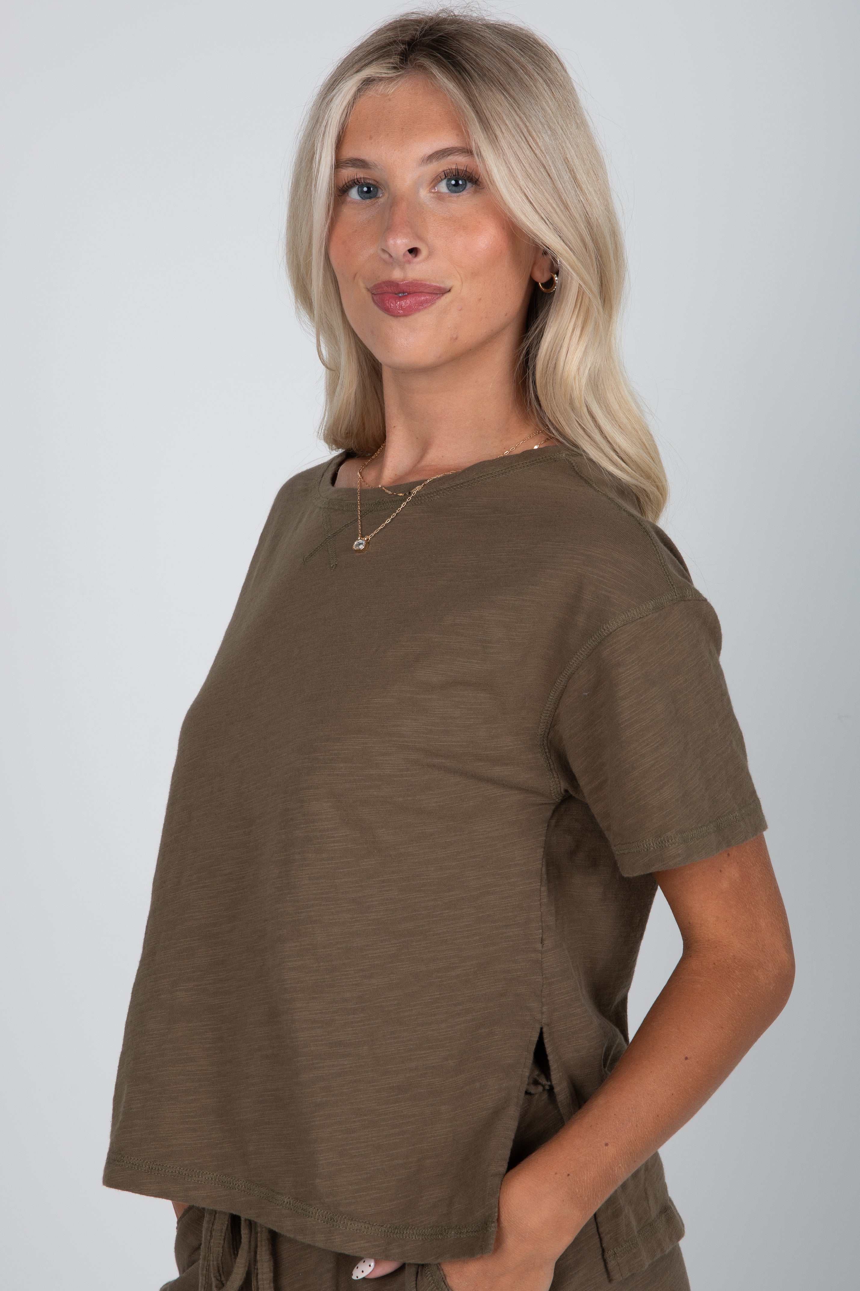 Woman wearing a brown t-shirt against a plain background