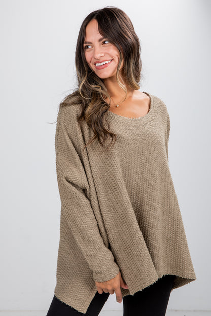 Woman wearing a beige sweater against a white background