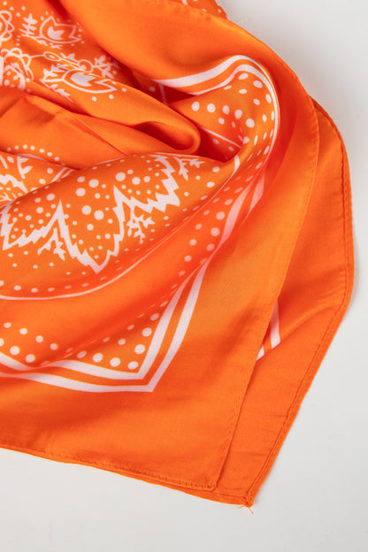 Orange bandana with white patterns on a light gray background