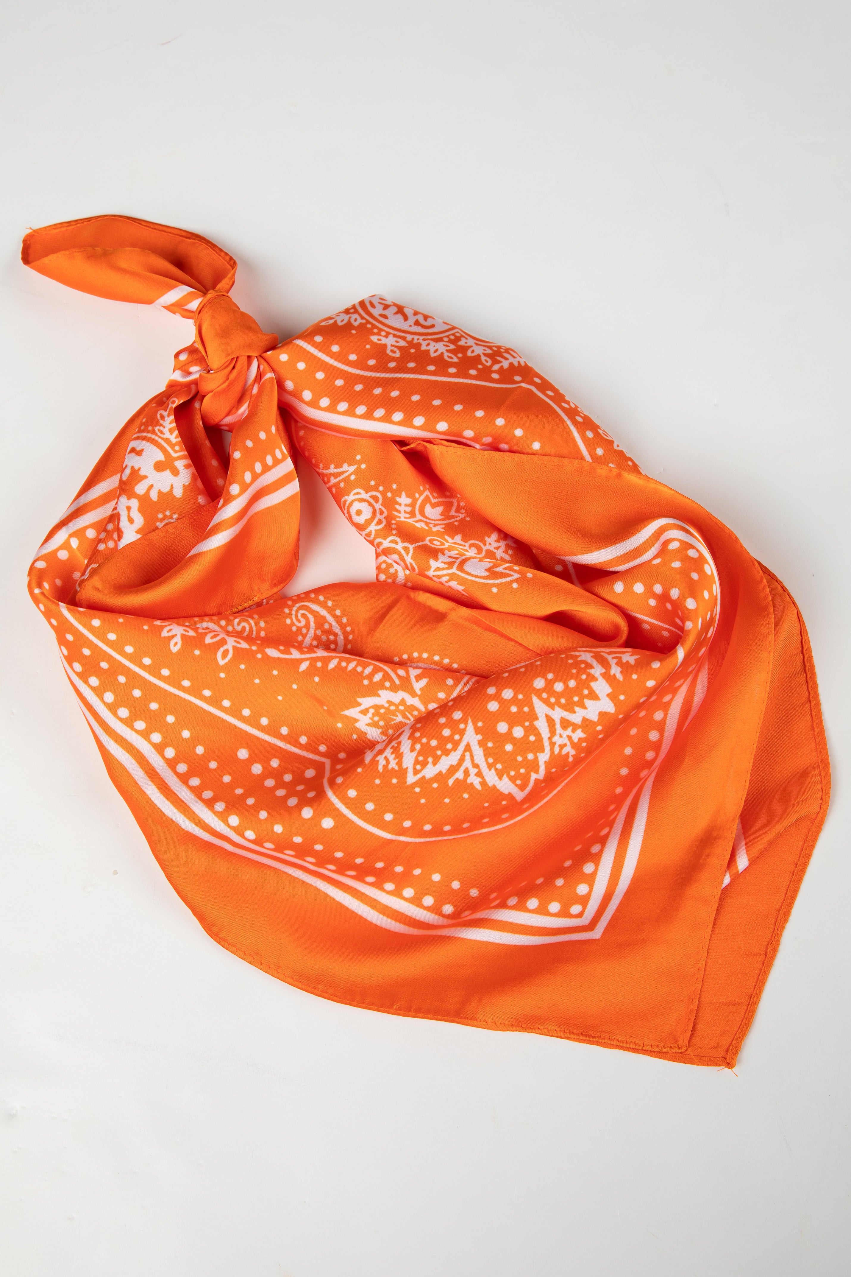 Orange bandana with white patterns on a light gray background