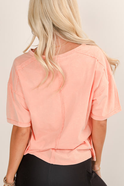 Person wearing a peach-colored top with a plain background