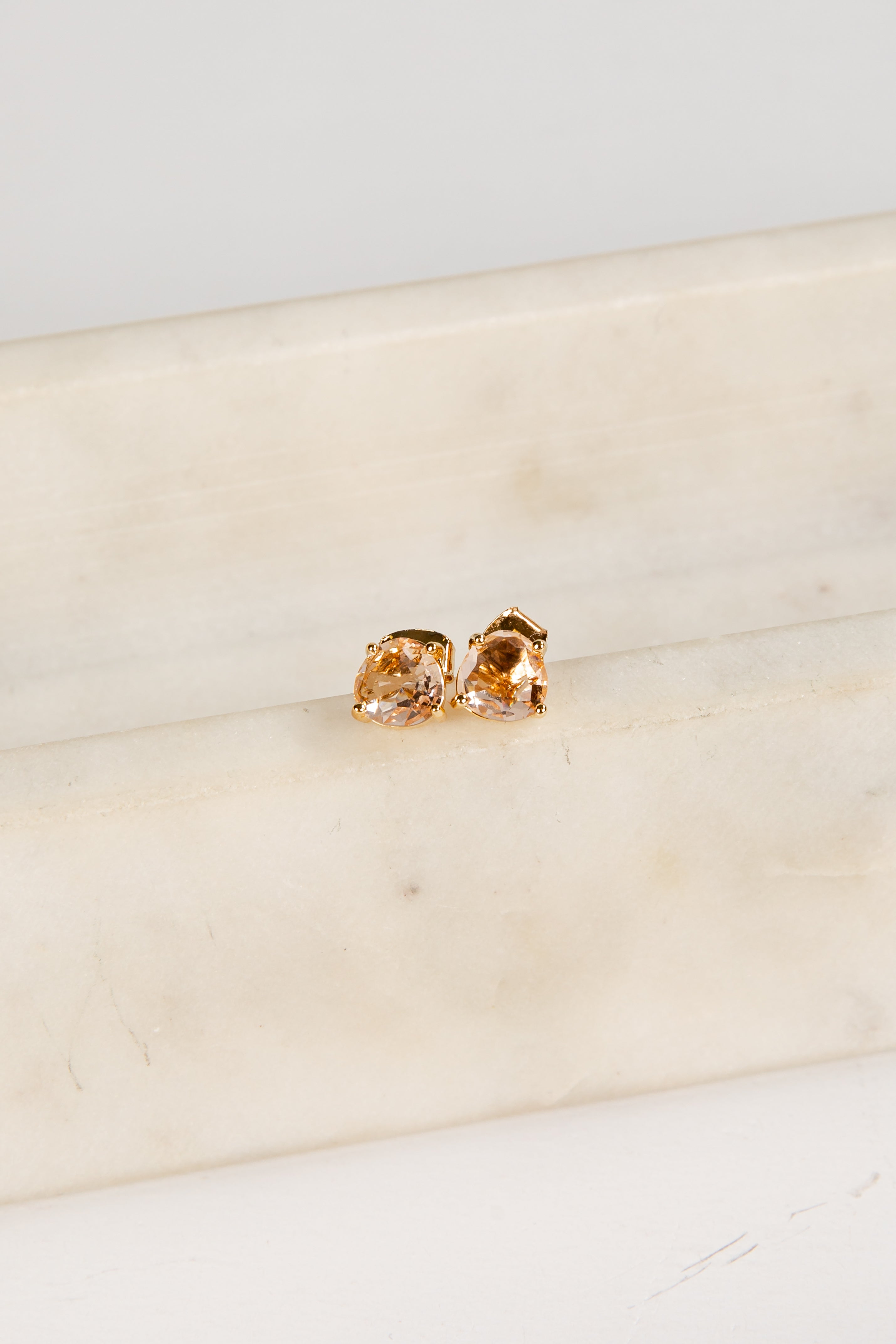 Gold earrings on a marble surface