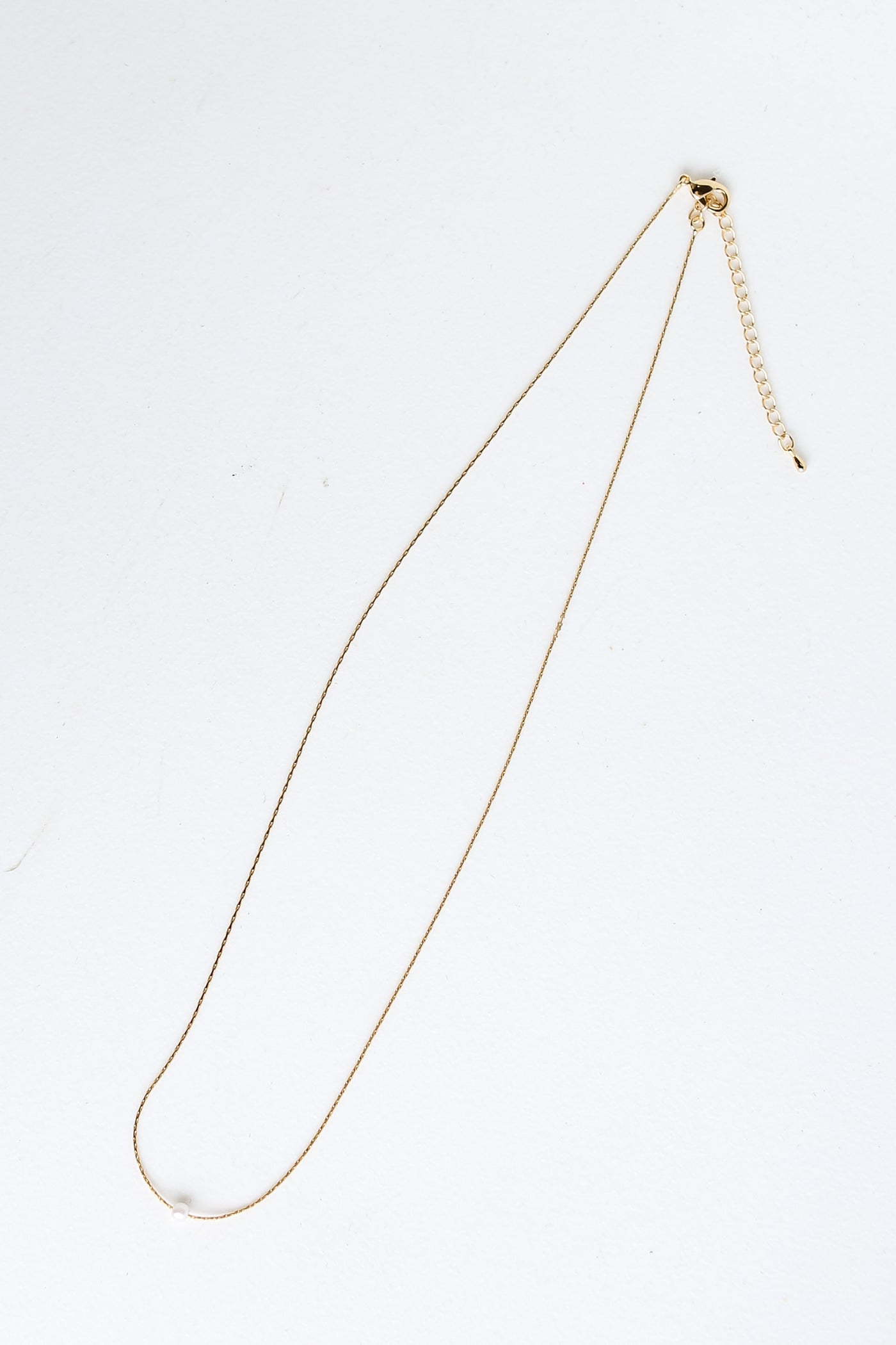 Gold Pearl Charm Necklace flat lay