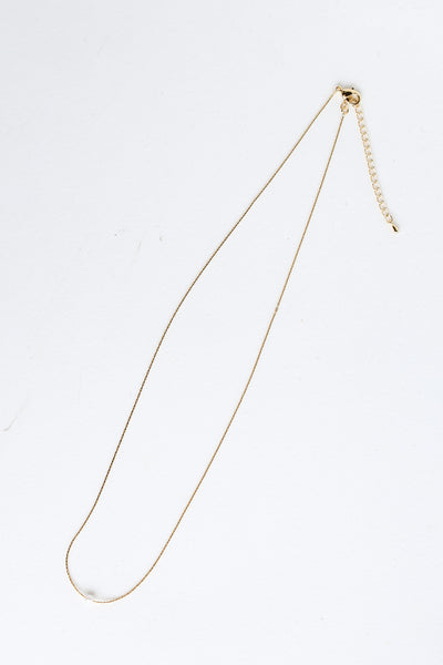 Gold Pearl Charm Necklace flat lay