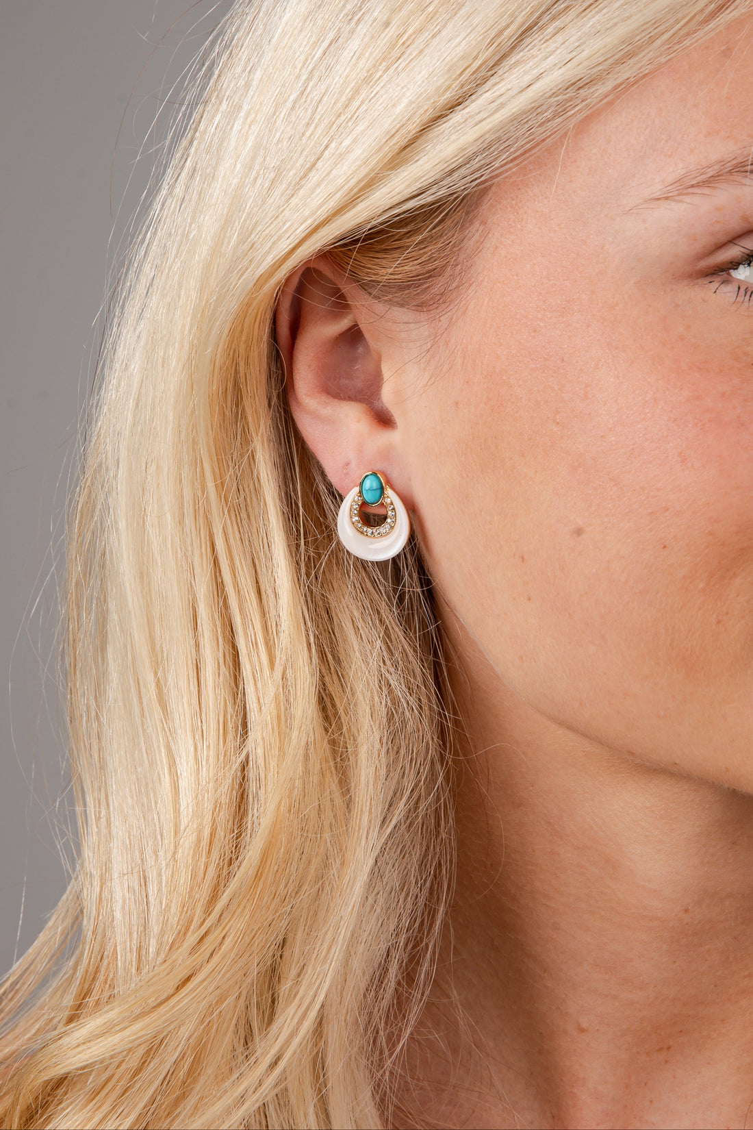 Close-up of a woman wearing earrings with a neutral background
