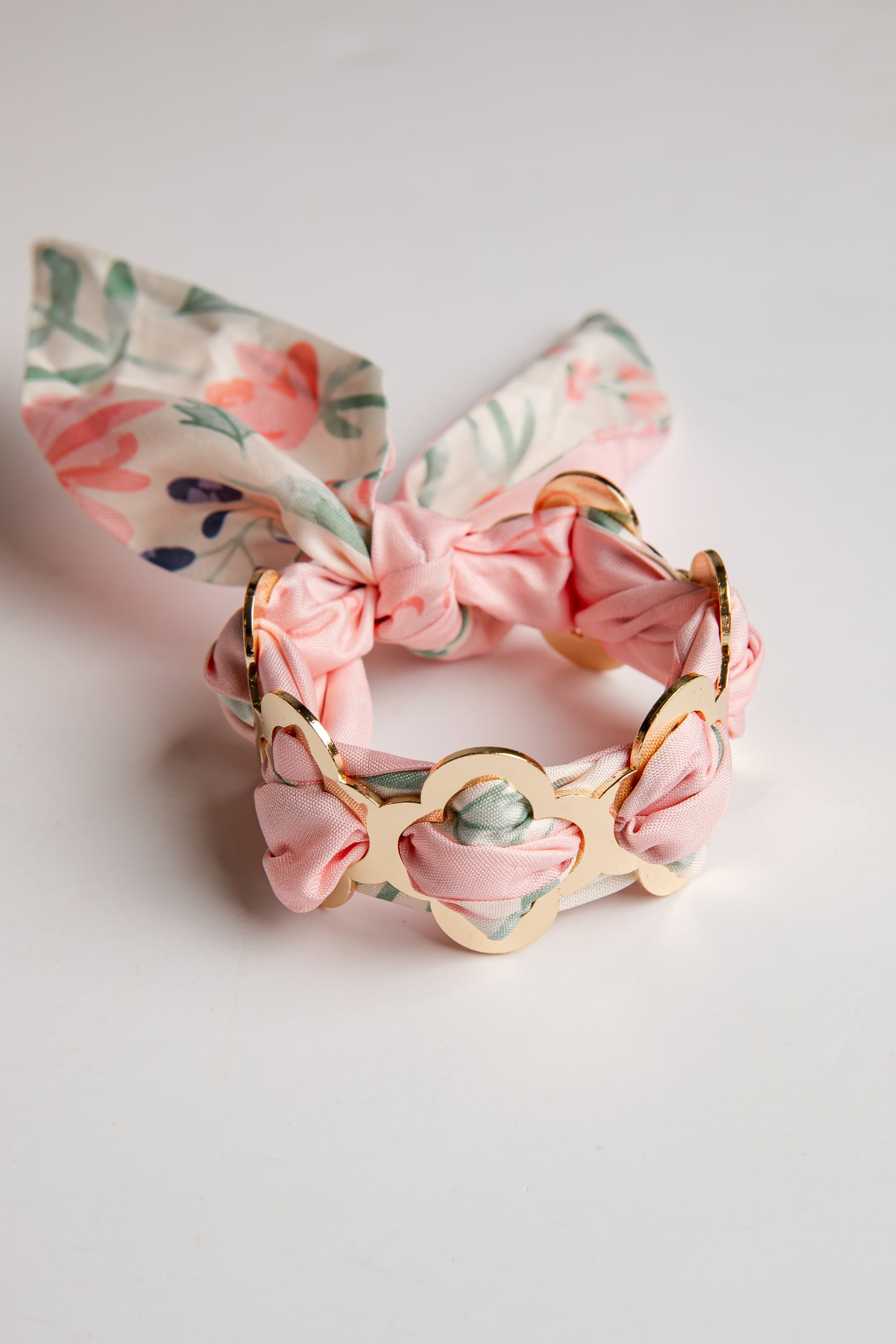 Floral bracelet with pink bow on a light gray background