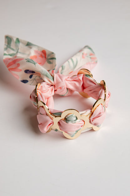 Floral bracelet with pink bow on a light gray background