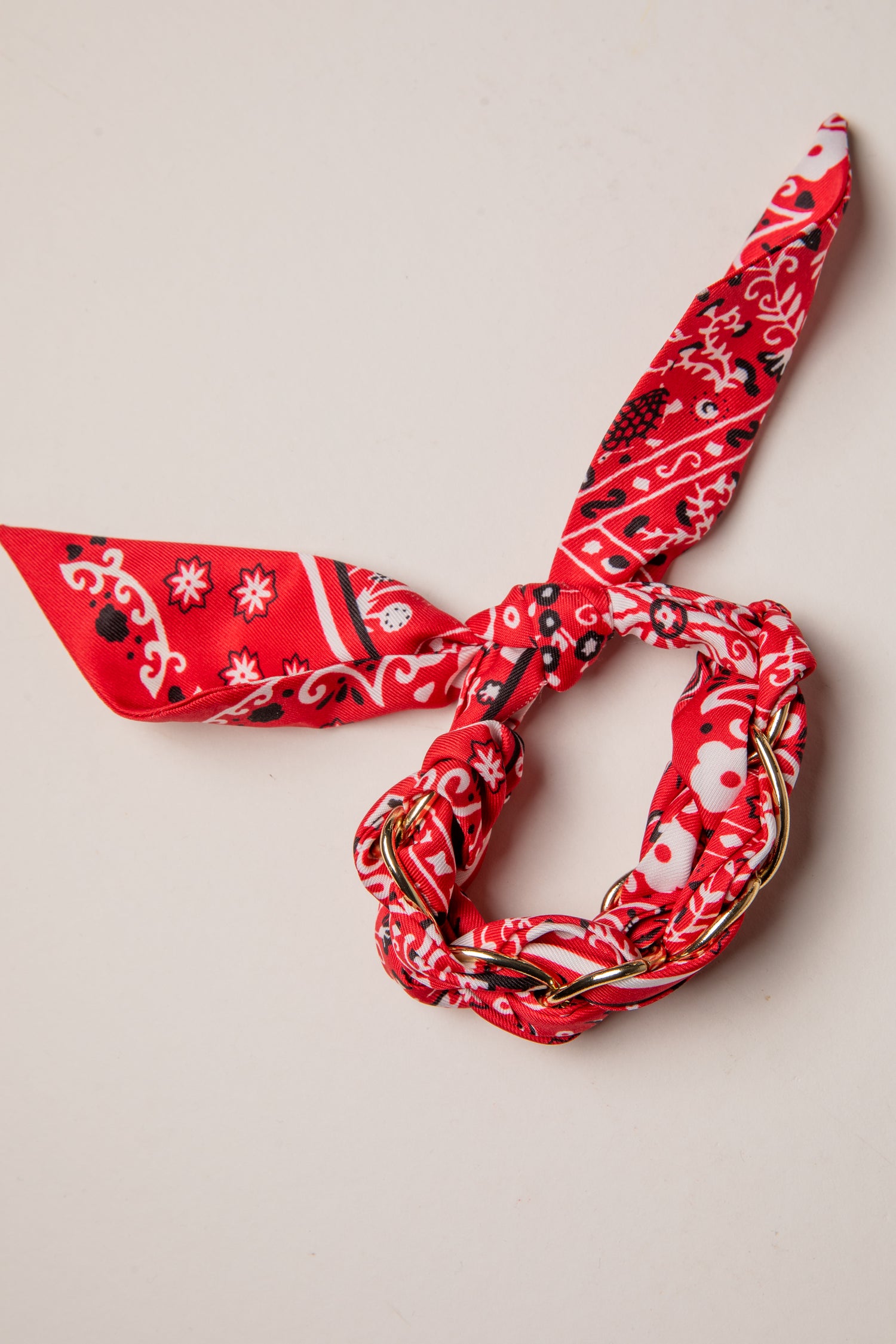 Red bandana with black and white patterns on a beige background