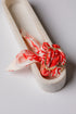 Decorative ring with red and white pattern on a white ceramic stand