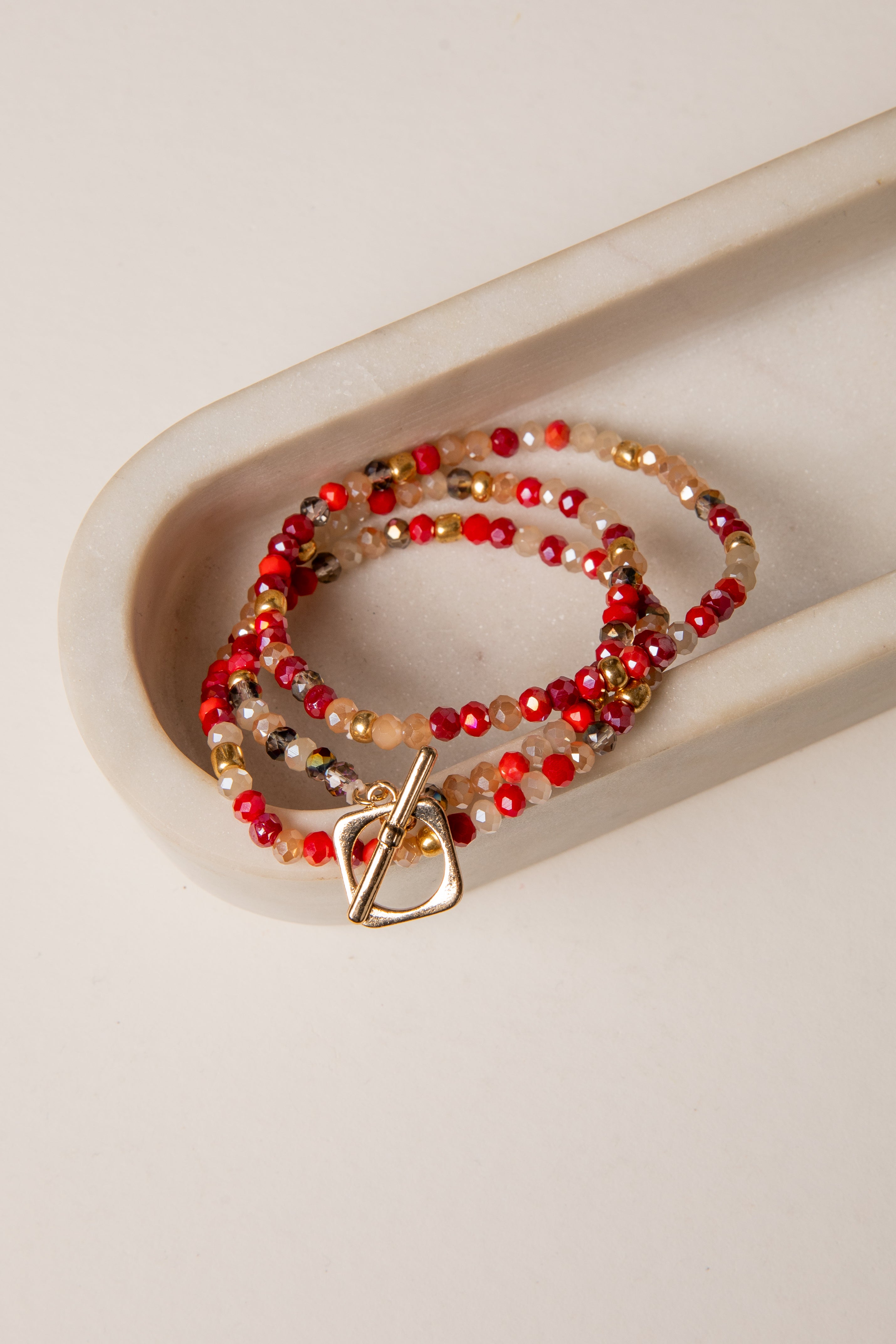 Beaded bracelet with a gold clasp on a beige surface