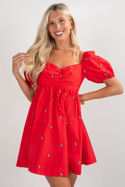 Woman wearing a red dress with puff sleeves on a white background