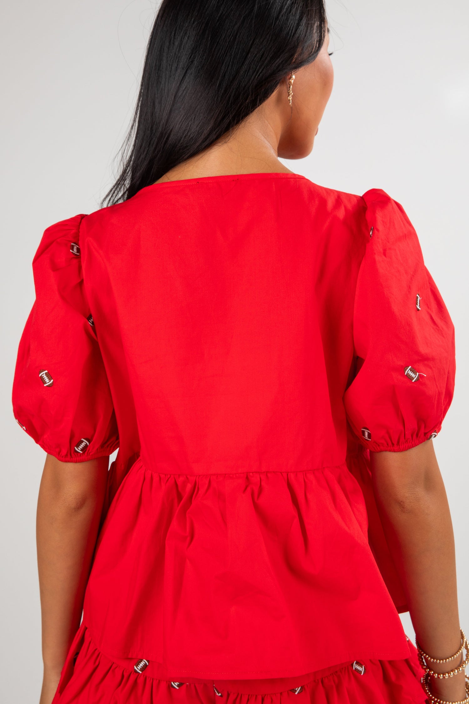 Red dress with puff sleeves worn by a person on a white background