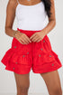 Red tiered shorts with a white top on a plain background