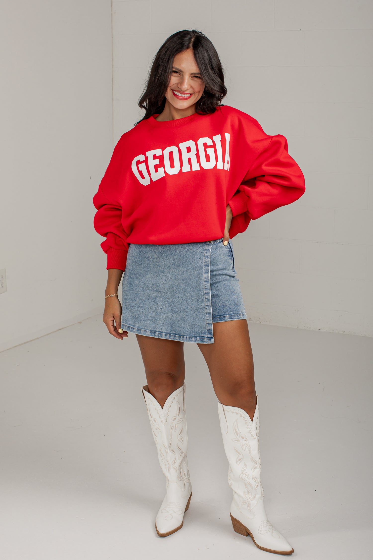 A woman modeling a bright red sweatshirt with &