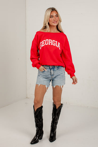 A woman modeling a bright red crewneck sweatshirt with &