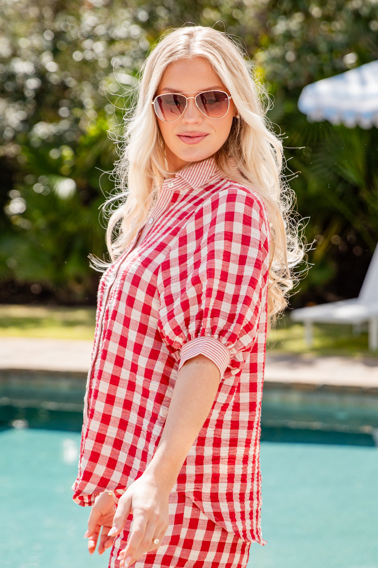 Woman wearing a red and white checkered outfit by a pool