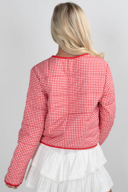 Person wearing a red and white checkered jacket on a gray background