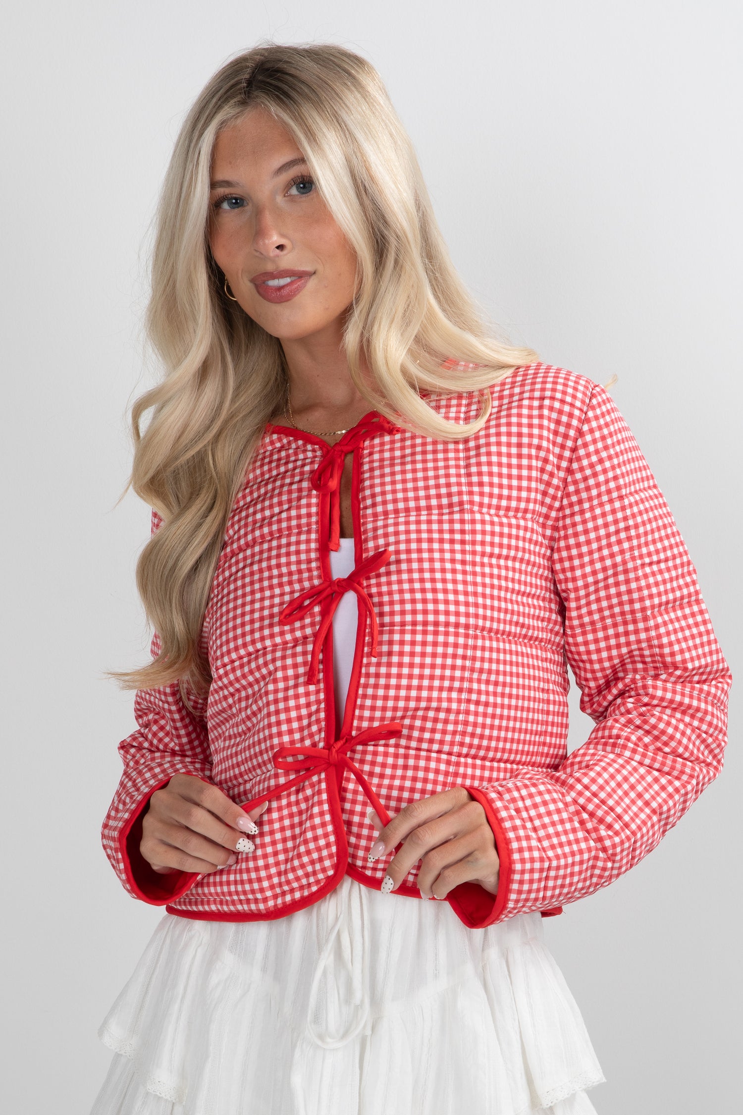 Woman wearing a red and white checkered jacket on a plain background